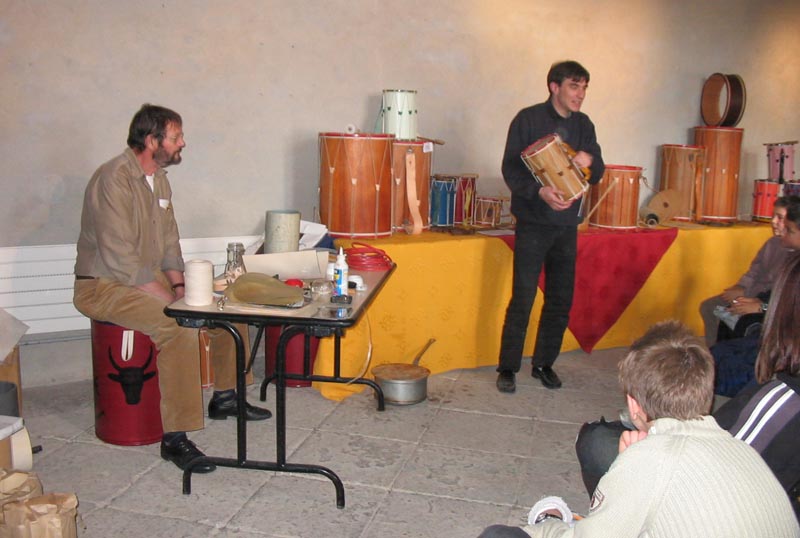 Thibaut PLANTEVIN avec l'aide de Rodolphe STOITZNER explique aux jeunes comment sont fabriqués les tambourins provençaux.